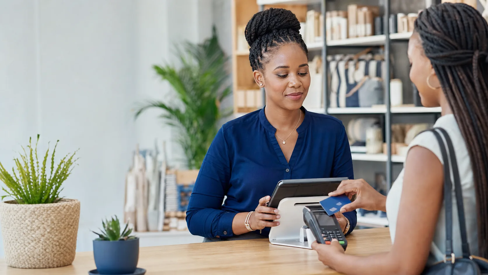 Retail manager using a point-of-sale system while a customer makes a card payment